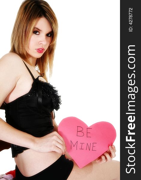 Beautiful young Hispanic woman in black lingerie holding pink heart that reads be mine. Beautiful young Hispanic woman in black lingerie holding pink heart that reads be mine.