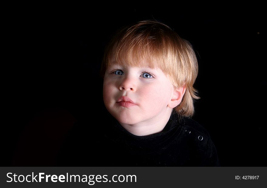 Young Boy with pensive and inquiring look on his face, dramatic lighting. Young Boy with pensive and inquiring look on his face, dramatic lighting