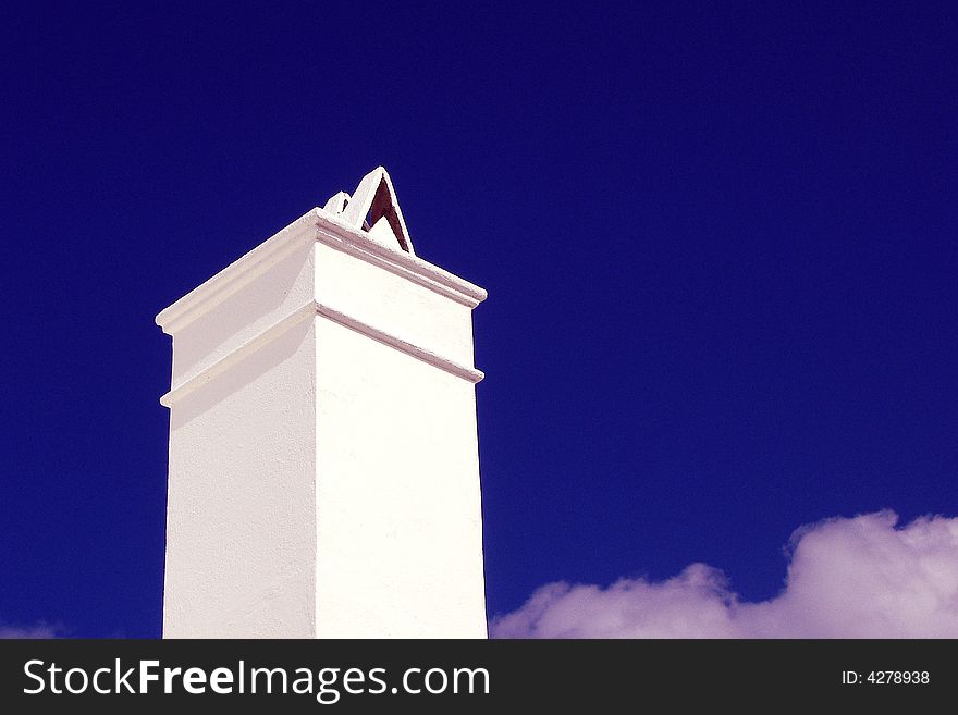 Tall white chimney against blue sky in Bermuda