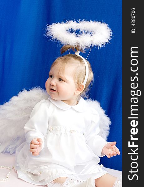 Girl angel in white clothes and with wings on a dark blue background