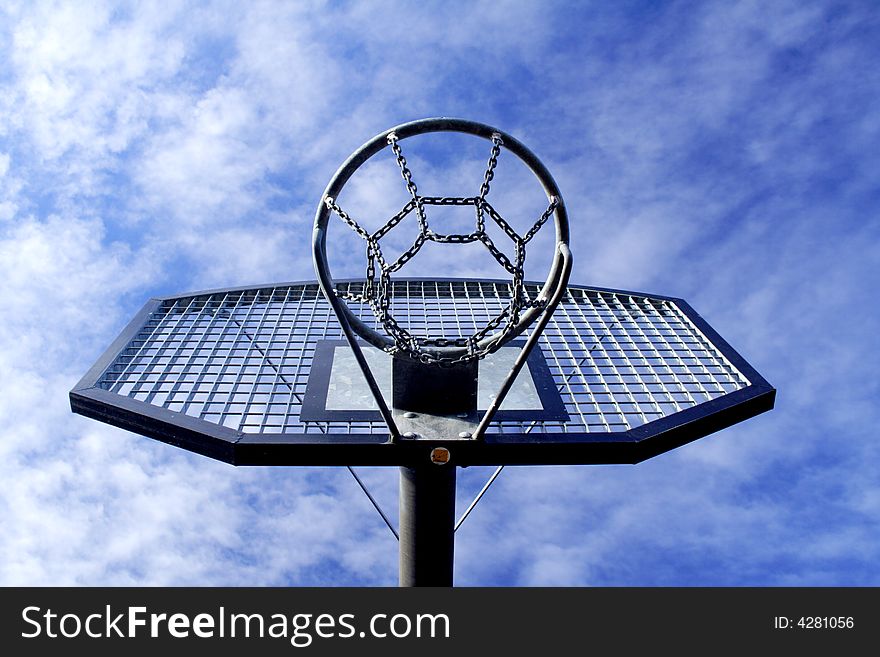 Basketball hoop and backboard set against a blue sky