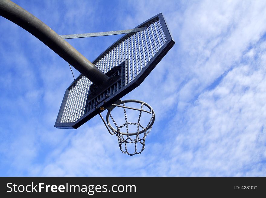 Basketball hoop and backboard set against a blue sky