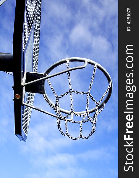 Basketball hoop and backboard set against a blue sky