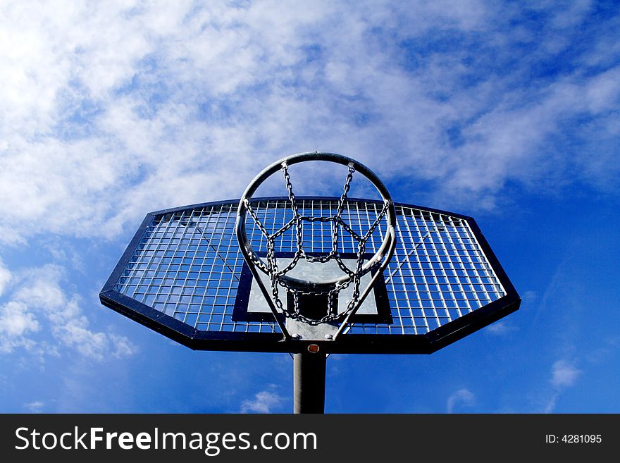 Basketball hoop and backboard set against a blue sky