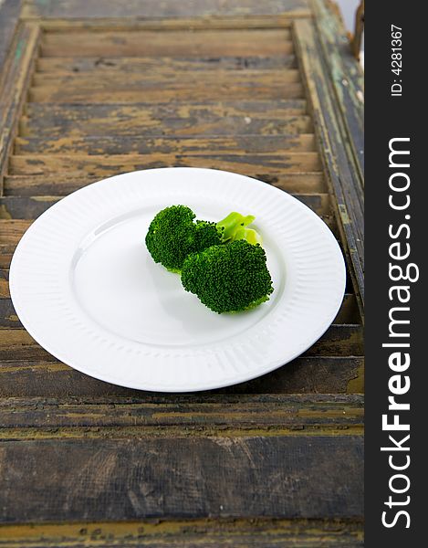 Green steamed broccoli on a white plate