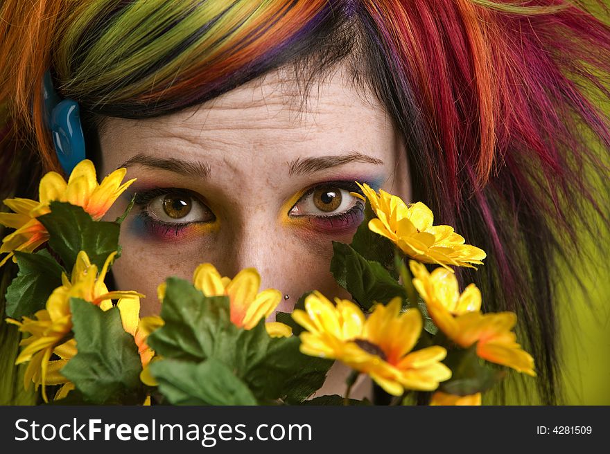 Pretty young woman peeks out from behind plastic flowers. Pretty young woman peeks out from behind plastic flowers.