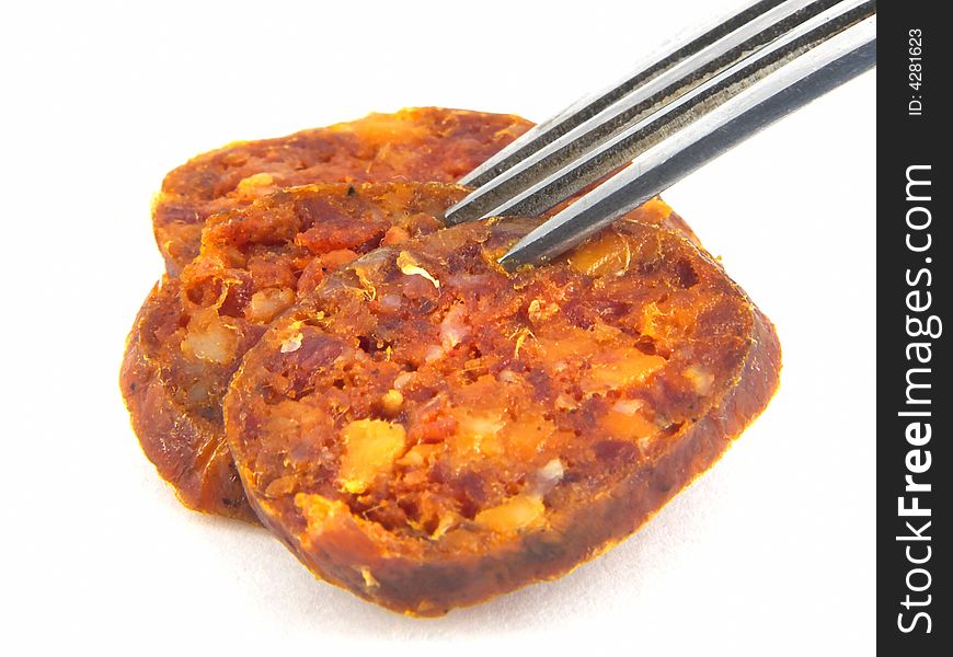 A home made, Hungarian style, smoked, paprika-spiced sausage (salami) and fork on white background. A home made, Hungarian style, smoked, paprika-spiced sausage (salami) and fork on white background