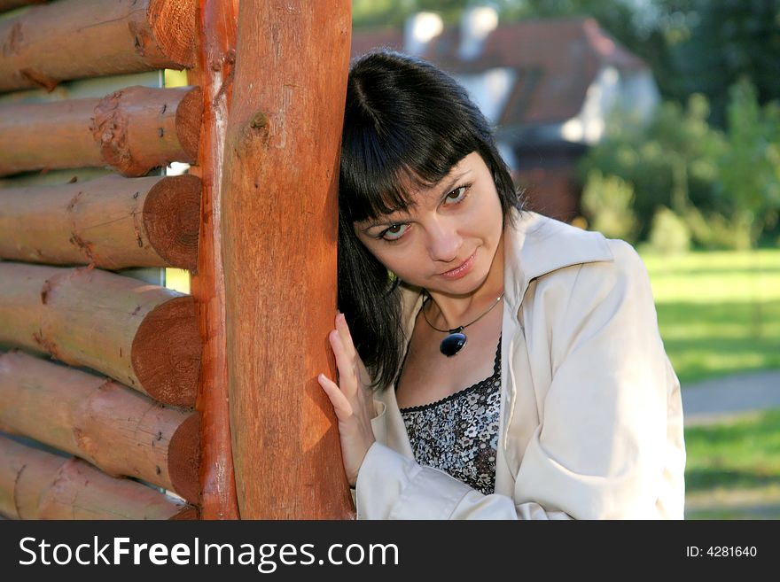 Beautiful woman staying near wooden fence in the park. Beautiful woman staying near wooden fence in the park