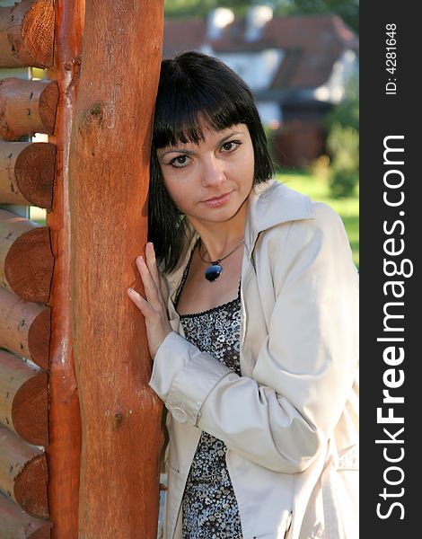 Beautiful woman staying near wooden fence in the park. Beautiful woman staying near wooden fence in the park