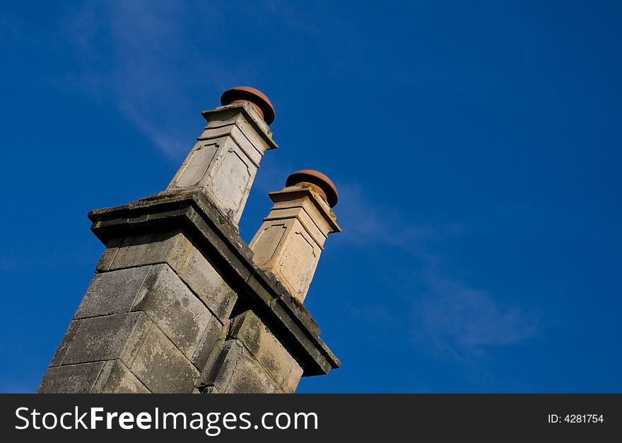 Old british chimney on a sunny day with clear blue sky.
