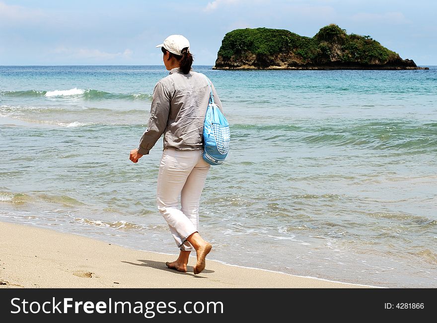 The girl is walking along Puerto Viejo shore, Costa Rica. The girl is walking along Puerto Viejo shore, Costa Rica.