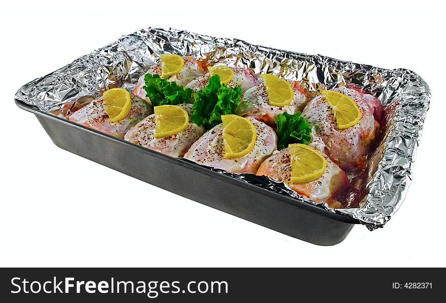 Seasoned chicken breasts with lemon slices in the tray. Seasoned chicken breasts with lemon slices in the tray