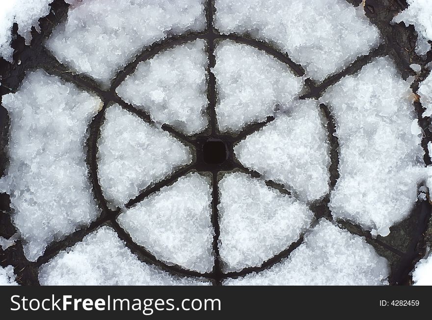 Detail of a road manhole covered by snow. Detail of a road manhole covered by snow