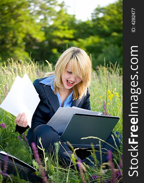 Happiness woman on grass with laptop and documents. Happiness woman on grass with laptop and documents