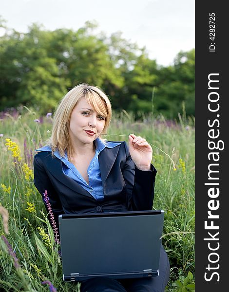 Contented businesswoman sitting on grass