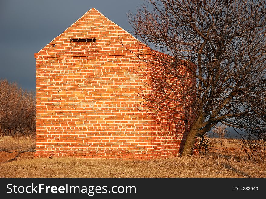 Brick building. A red brick, a dry tree. Brick building. A red brick, a dry tree