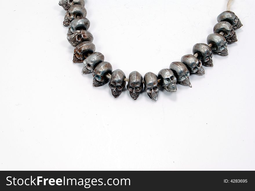 Dye cast pewter figurine skulls, beads on string. Dye cast pewter figurine skulls, beads on string