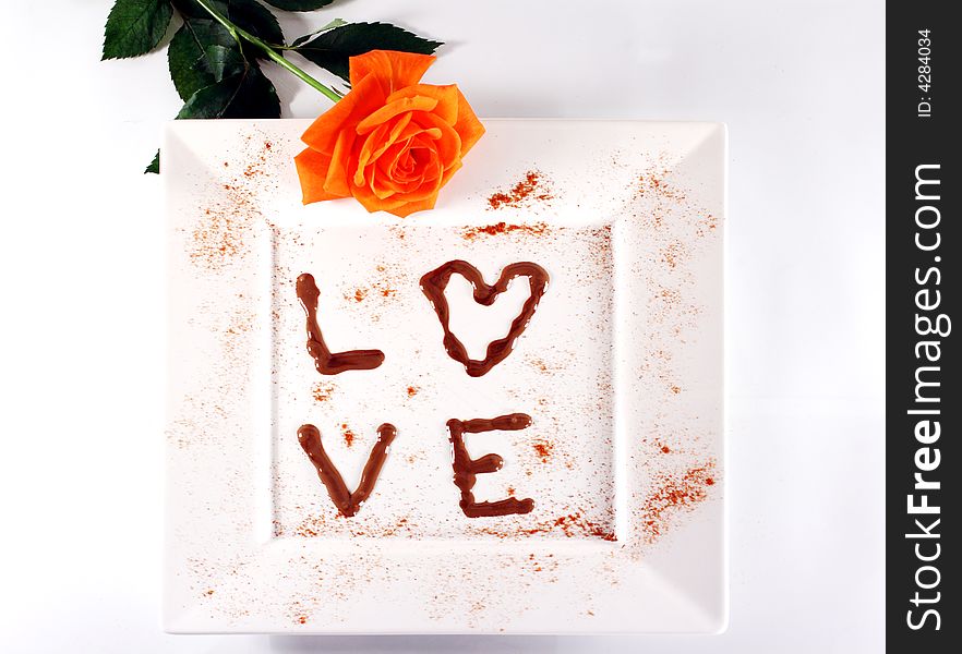 Love in chocolate on white plate with rose. Love in chocolate on white plate with rose.