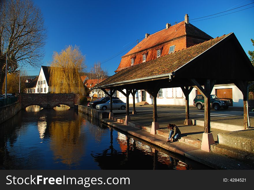 Old wash house in a city with a girl sitting