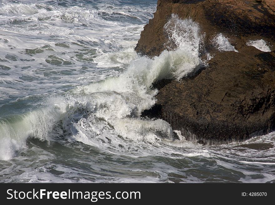 Pacific Ocean Waves break against the rocks.