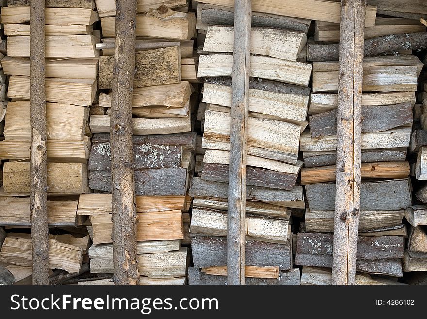 Photo of stacked firewood in storage until winter. Photo of stacked firewood in storage until winter.