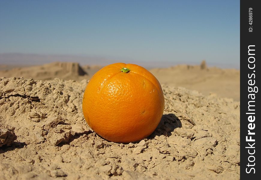 an orange in the desert alone