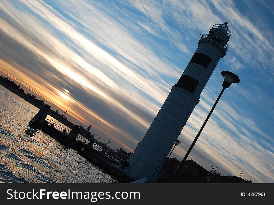 The lighthouse of the isle of Murano at sunset, near Venice in Italy