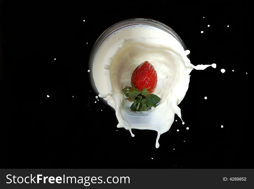 A strawberry falling into a bowl of milk with a splash. A strawberry falling into a bowl of milk with a splash.