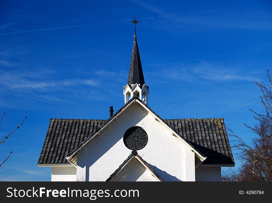 Top part of a chapel on burial-grounds and blue sky. Top part of a chapel on burial-grounds and blue sky