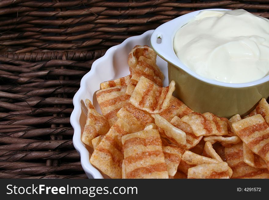 Chips in a white bowl with dip in a green bowl. Chips in a white bowl with dip in a green bowl