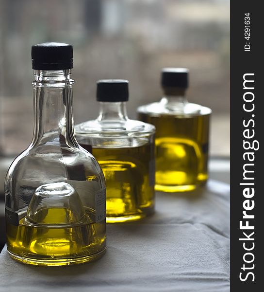 Three bottles of olive oil at the window