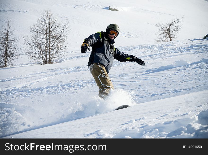 The snowboarder riding on a virgin soil (extreme sport)