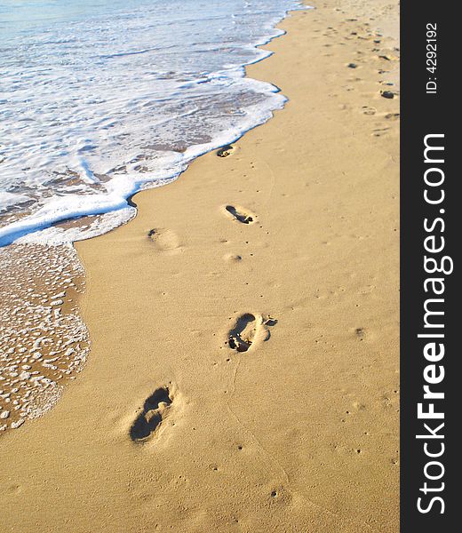 Footprints on sand by the sea surf. Footprints on sand by the sea surf