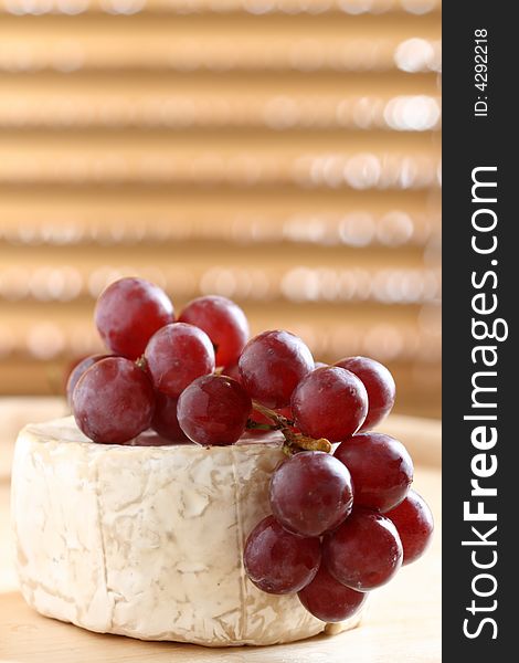 Red grape and soft cheese on wood, shallow dof.