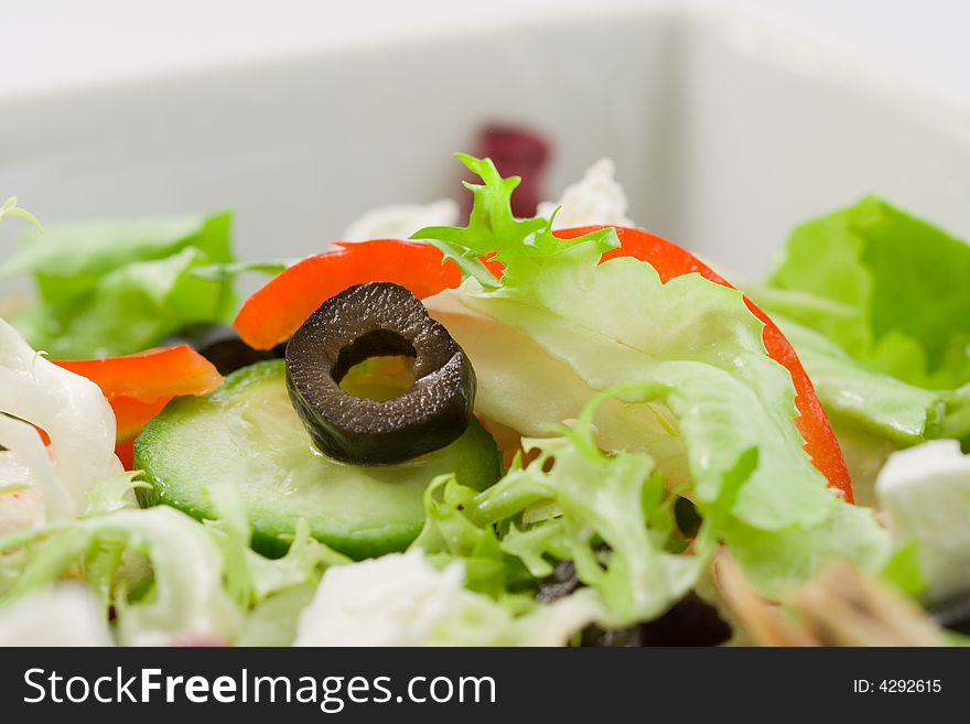 Macro shot of a Mediterranean salad with an olive slice in focus. Macro shot of a Mediterranean salad with an olive slice in focus