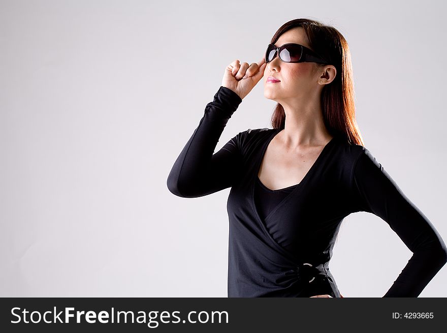 Woman in dark navy blue top wearing a pair of sunglasses. Woman in dark navy blue top wearing a pair of sunglasses