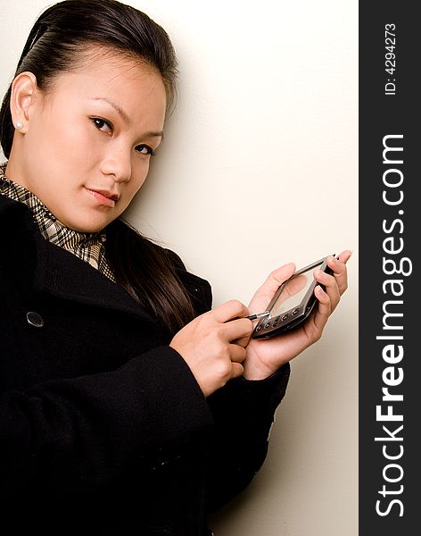 Asian Female entering information into her handheld computer. Asian Female entering information into her handheld computer.