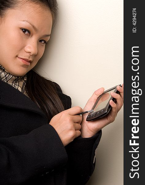 Tighter shot of asian female entering data into her handheld device. Tighter shot of asian female entering data into her handheld device