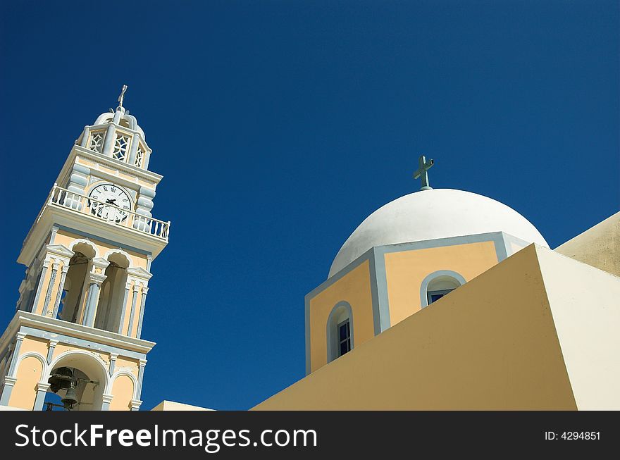 Leaning clock tower and church in Santorini