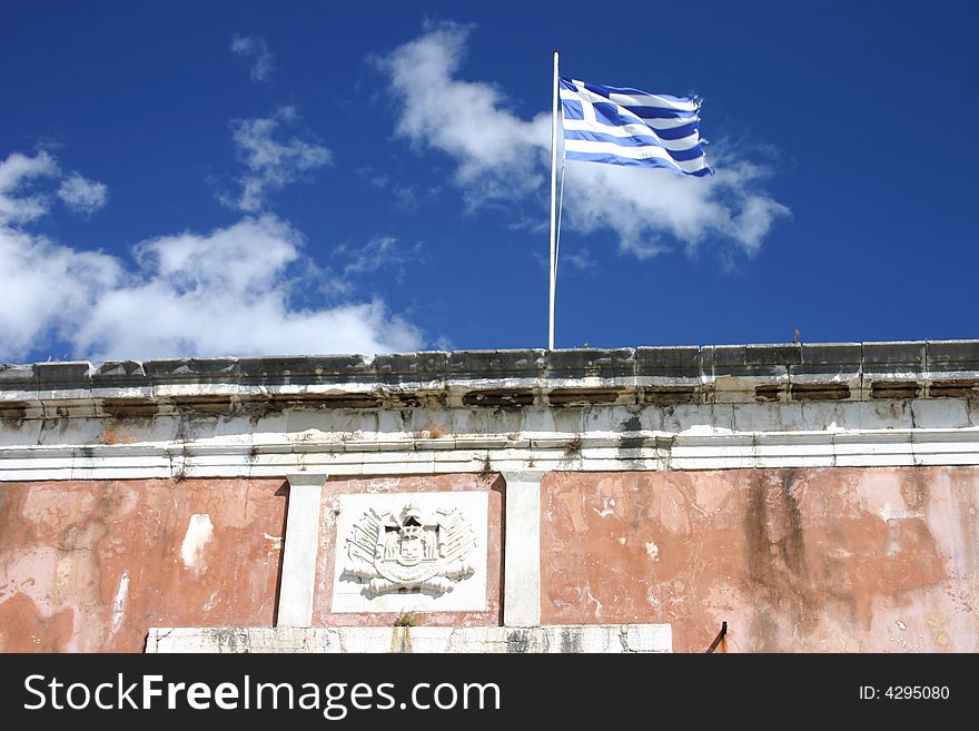 Greek flag in front of old fortress in Corfu town, Greece