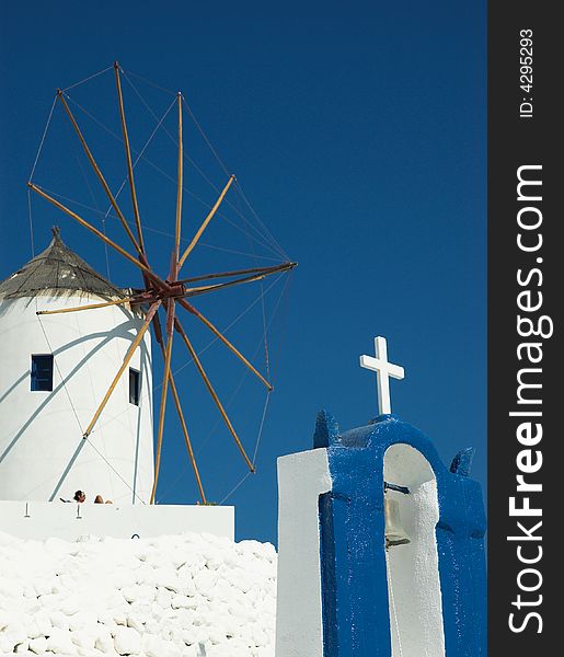 Old windmill and belltower in sunny Santorini