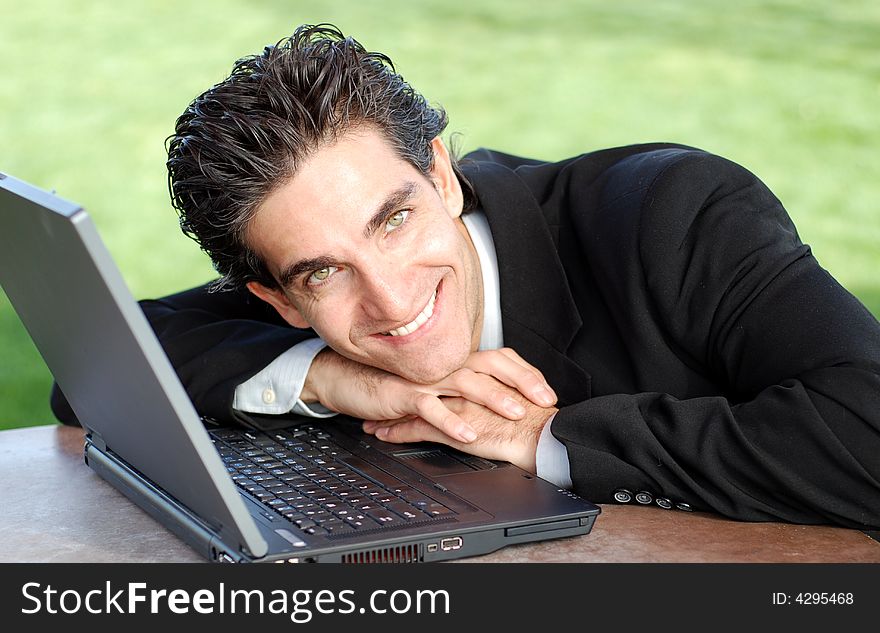 Confident and successful young adult businessman working on his laptop computer