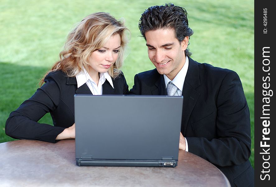 Portrait of a confident and successful business team posing together with a laptop. Portrait of a confident and successful business team posing together with a laptop