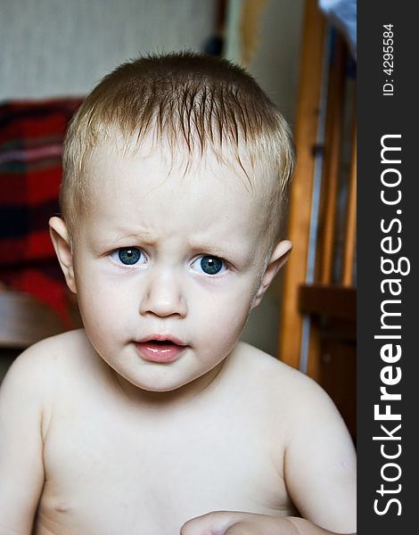 Little boy with blue eyes sitting on the floor