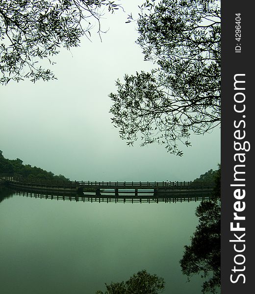 A lake with bridge and tree after rain. A lake with bridge and tree after rain