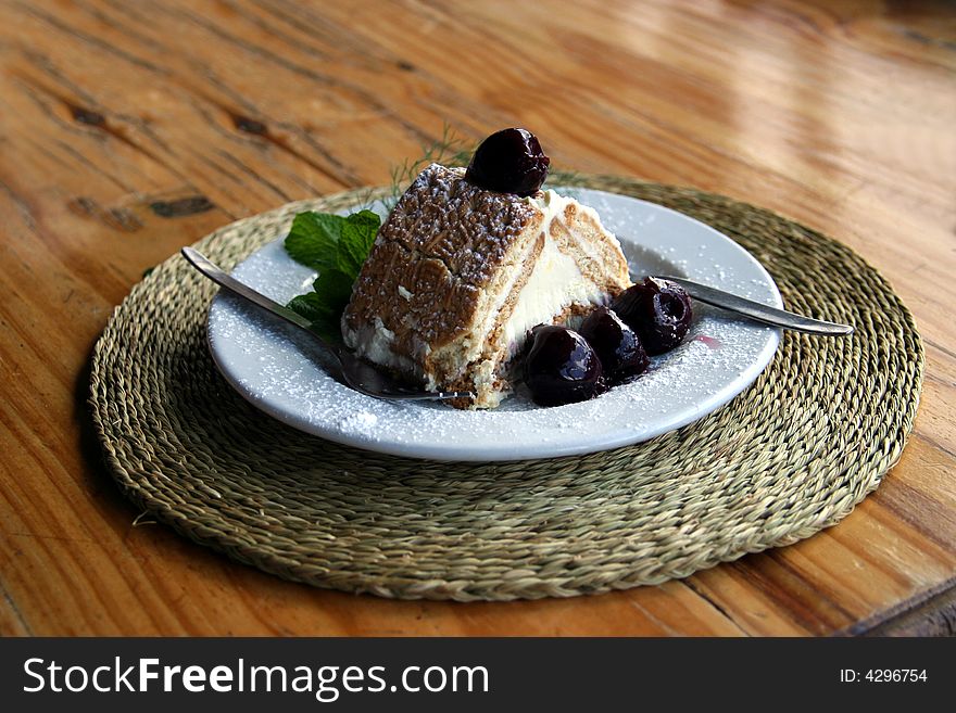 A slice of yummy Cheesecake with cherries on a plate