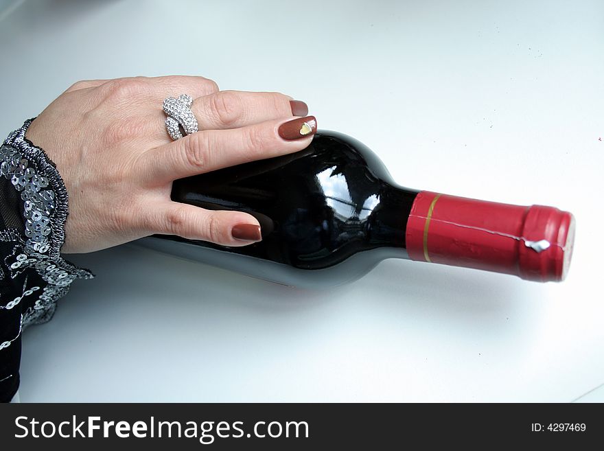 Female hand with bottle of red wine. Female hand with bottle of red wine