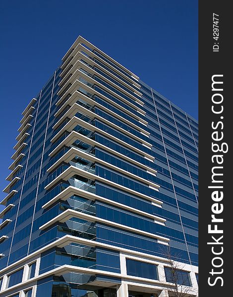 A blue glass office building with white corners. A blue glass office building with white corners