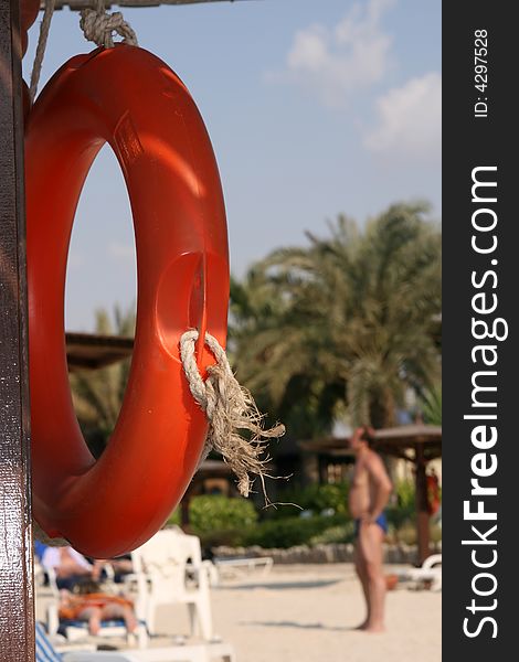 Orange decorative life vest under a beach umbrella