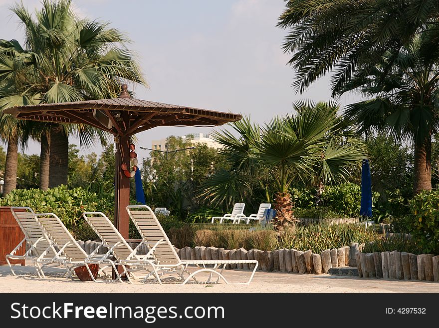 Wooden umbrella and beach chairs on the sand